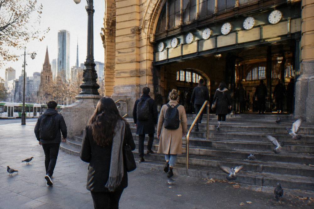 A small tour group gathered under the clocks at the entrance of Flinders Street Station