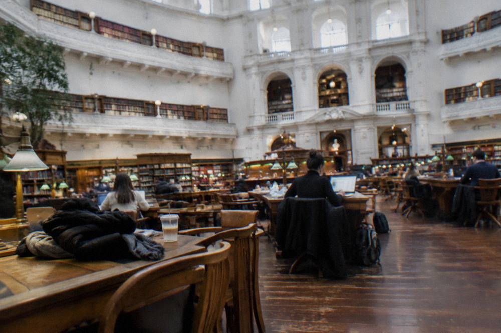 Visitors reading beneath the domed ceiling of the State Library Victoria reading room