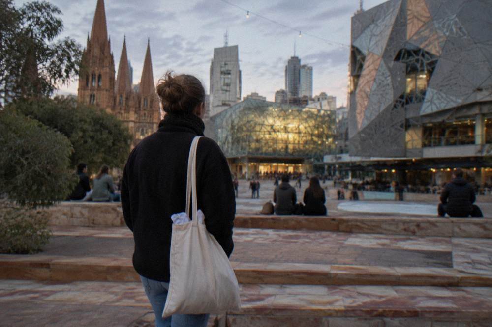 A tour guide holding a collection bag while talking with visitors at the end of a city walk