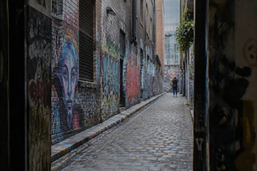 A narrow Melbourne laneway covered floor to ceiling in colorful spray paint murals