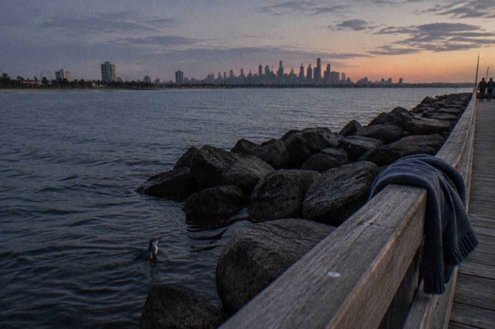 The St Kilda breakwater and pier at dusk with the city lights beginning to show across the water