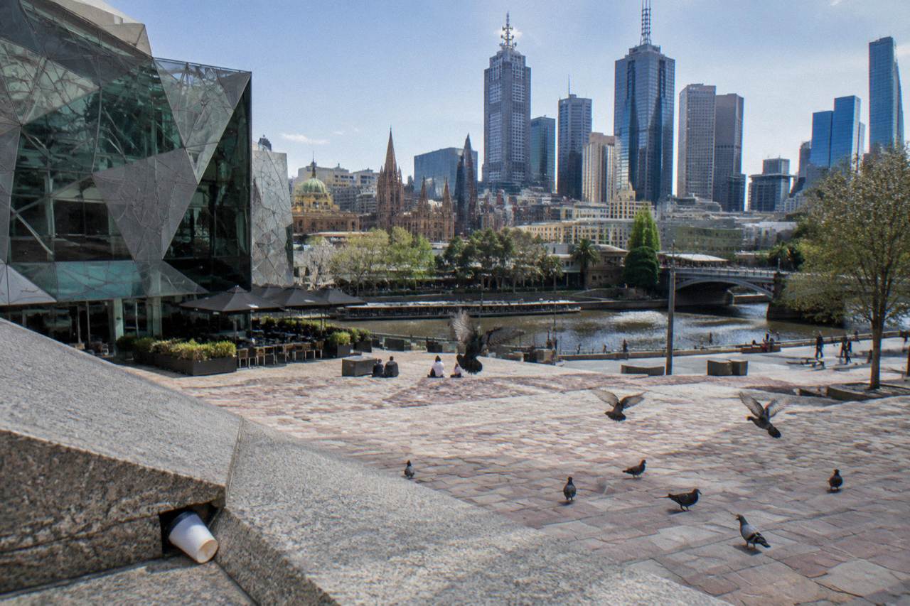 Melbourne's Federation Square on a bright day with the Yarra River and city skyline behind it