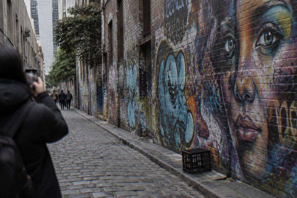 Visitors walking through the graffiti-covered walls of Hosier Lane in central Melbourne