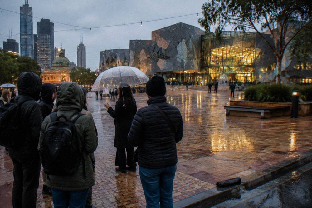 A tour guide holding an umbrella addressing a small group outside a historic Melbourne building