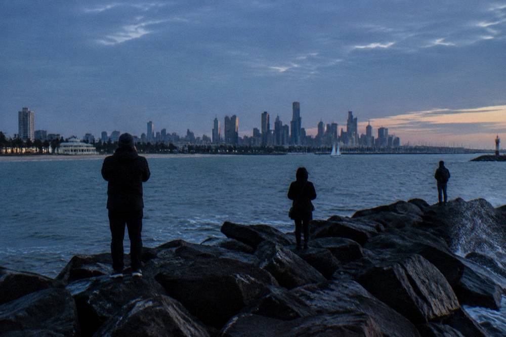 People gathered on the St Kilda breakwater at dusk watching for little penguins
