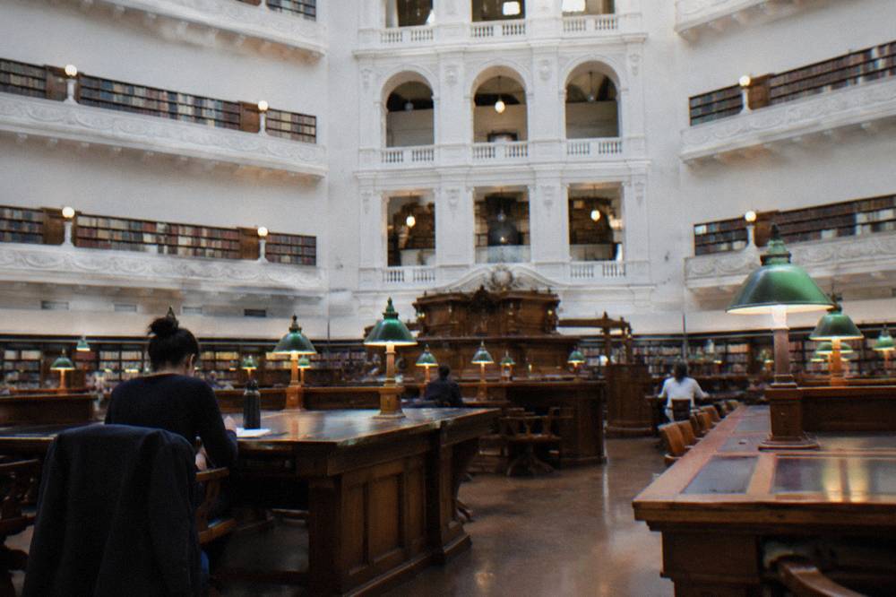 Visitors reading beneath the domed ceiling of the State Library Victoria reading room