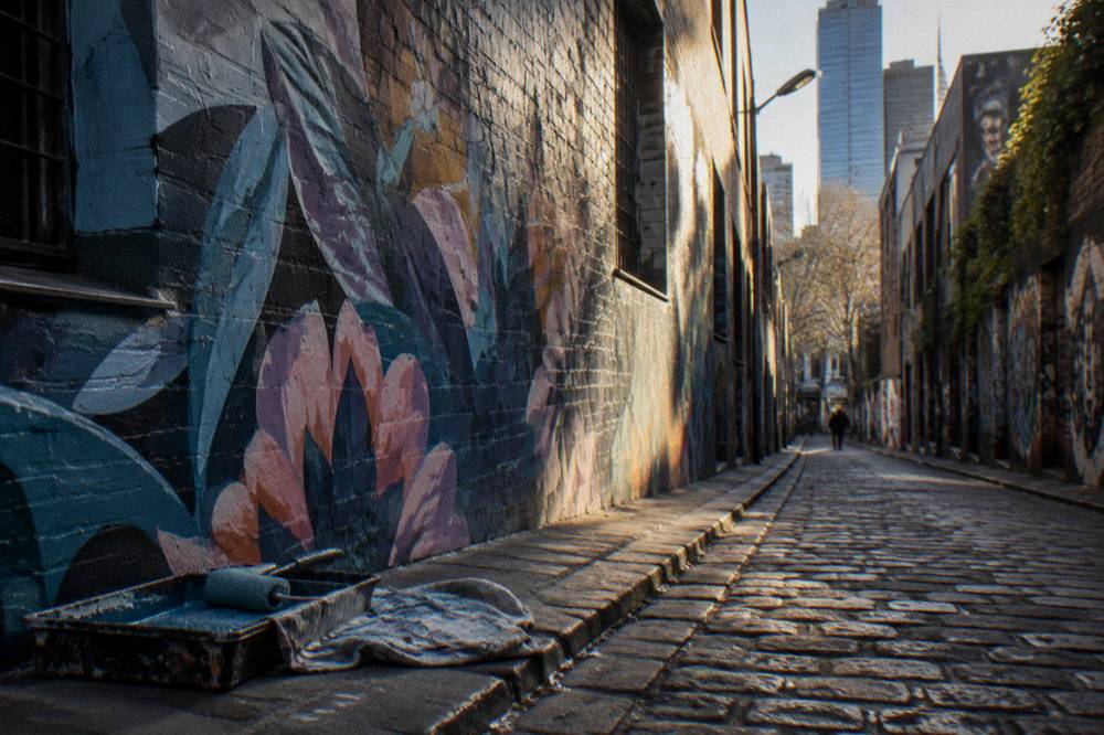 Morning light falling on freshly painted graffiti in an empty laneway