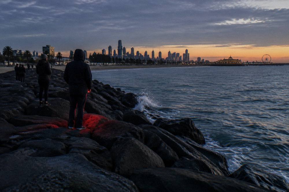 Visitors standing quietly along the St Kilda breakwater watching for penguins after sunset